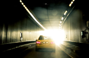 Ein Auto, dass im Petueltunnel ins Licht fährt. Es ist gelb